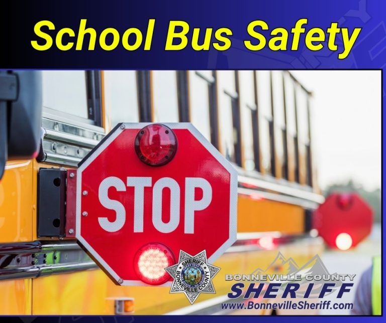 A stop sign is extended from a yellow school bus. Text reads "School Bus Safety" and "Bonneville County Sheriff www.BonnevilleSheriff.com" with the sheriff’s badge logo visible.