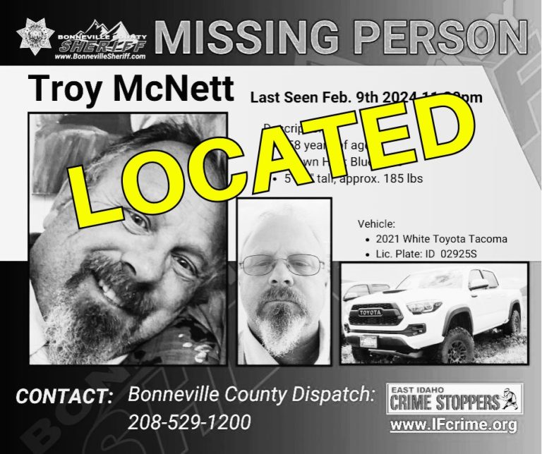 Missing person poster for Troy McNett with two photos of him and an image of a white Toyota Tacoma truck. The word "LOCATED" is stamped in large yellow letters across the poster. Contact and crime stopper info are listed.