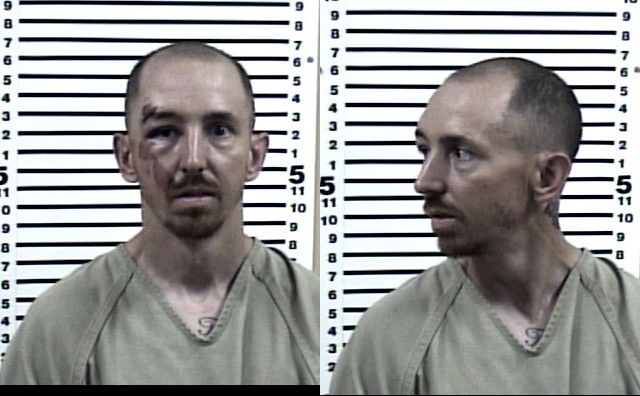 Two mugshot photos of a man wearing a beige prison uniform, shown facing forward and in profile. He has short hair, a goatee, facial injuries, and a chest tattoo. A height chart is visible in the background.